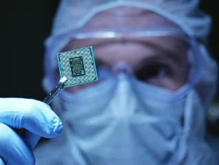holding up a microchip in closeup