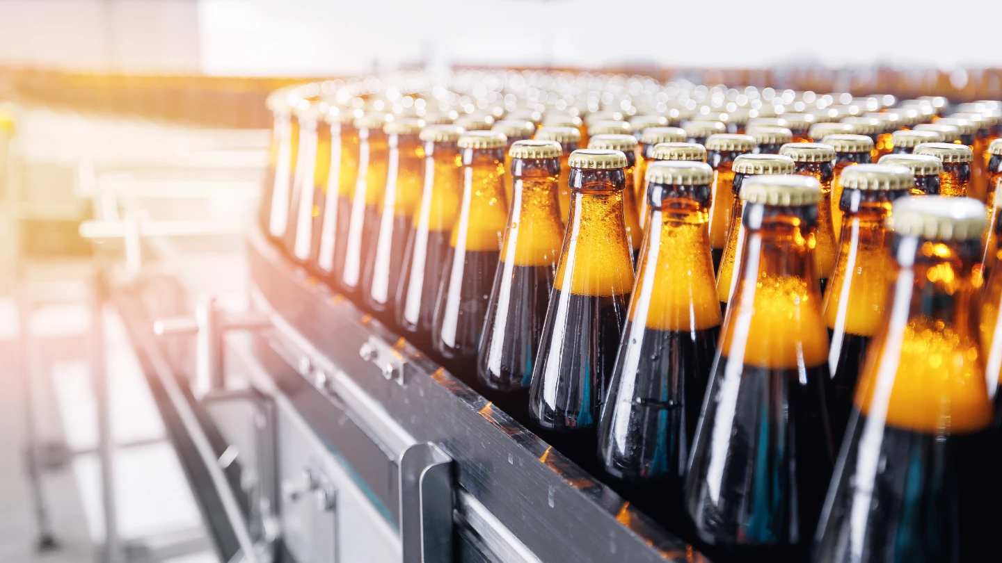 filled bottles lined up at a factory