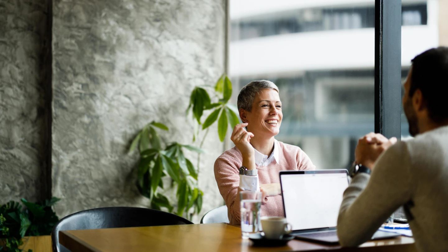woman and man talking behind laptop right 