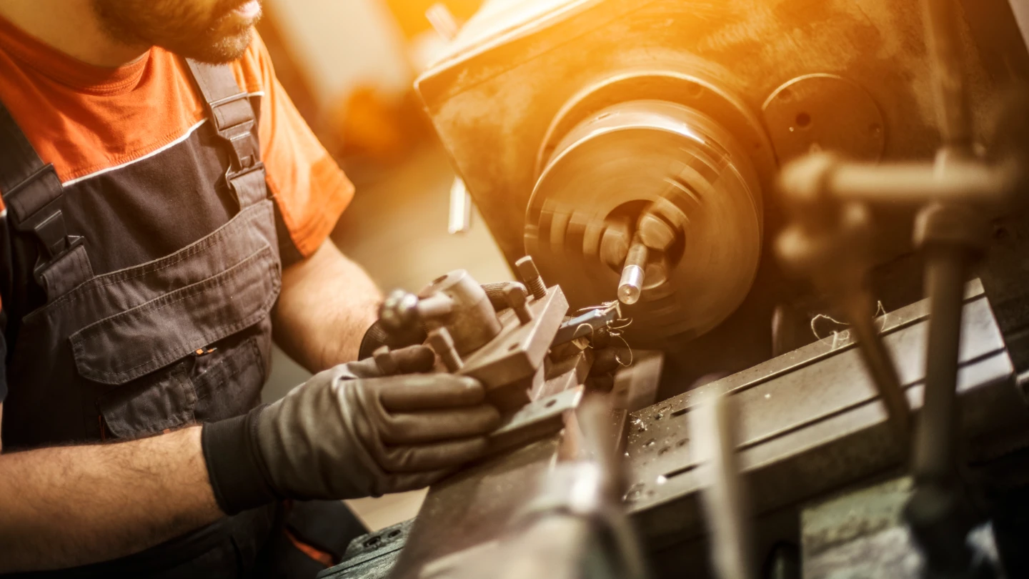 Male engineer drilling machine parts