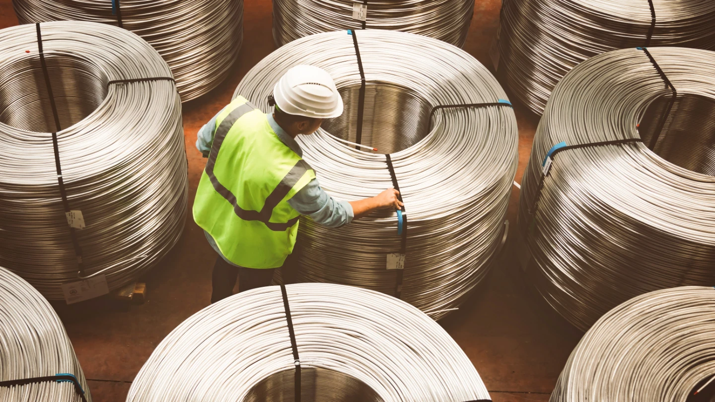 Male worker examining metal coils